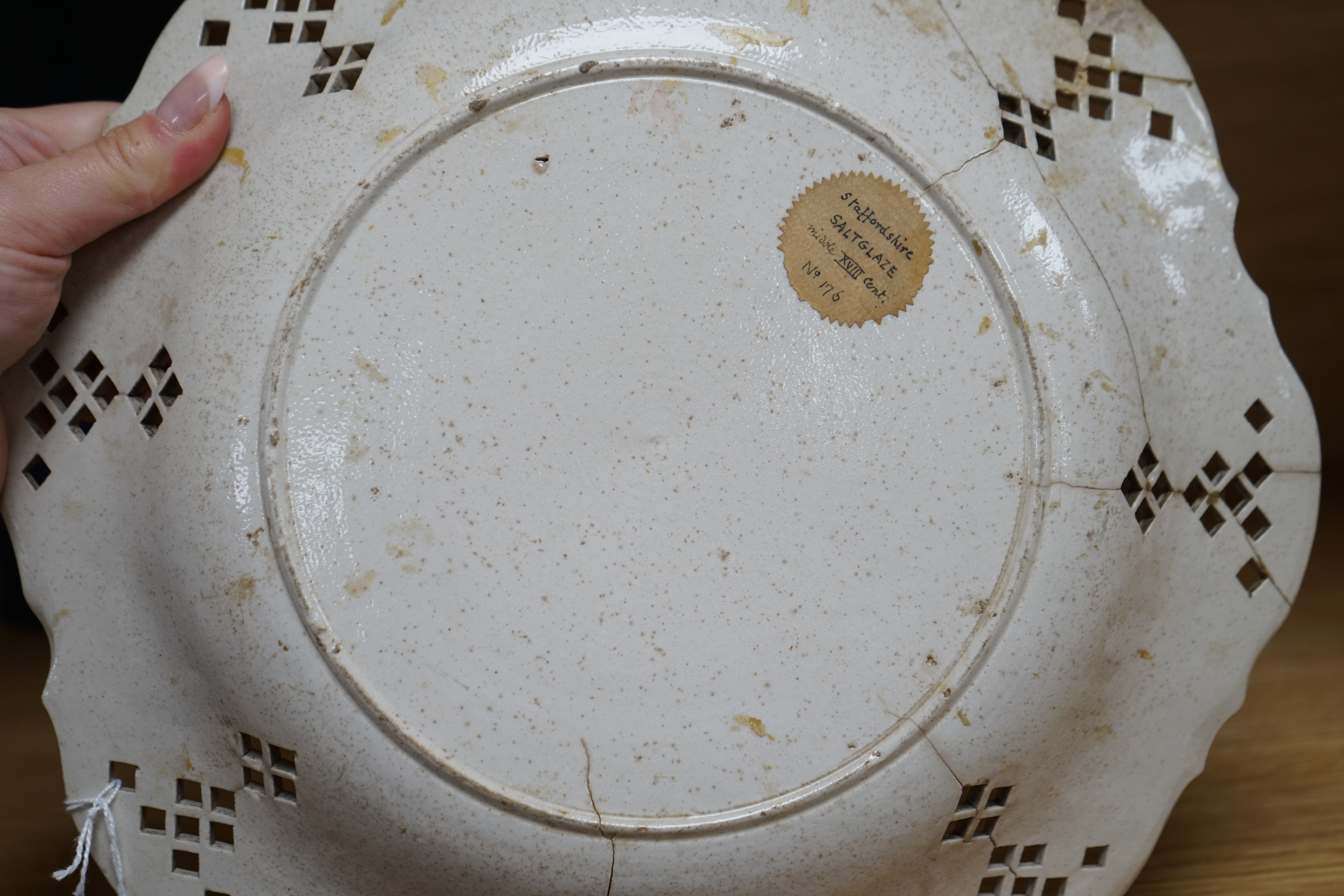 An 18th century white salt-glaze dish (a.f.), diameter 31cm. Condition - poor, significant cracks and repair